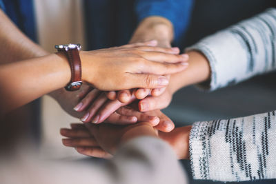 Cropped image of business people stacking hands