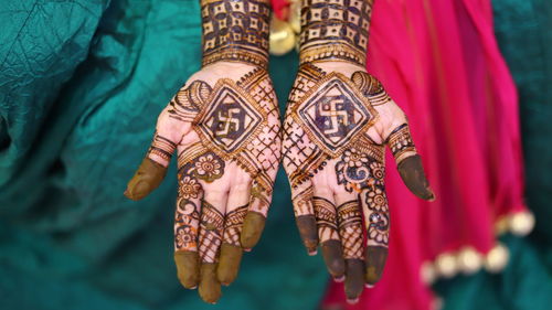 High angle view of woman showing henna tattoo during wedding ceremony