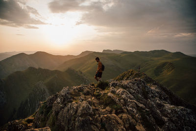 Full length of man standing on rock against sky