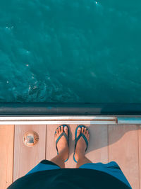 Low section of man standing in swimming pool