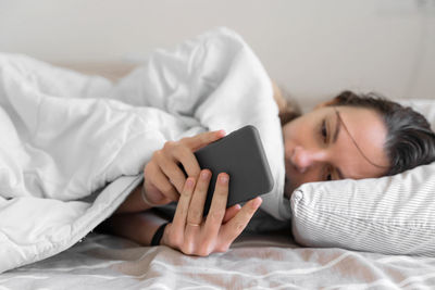 Woman lying on bed at home