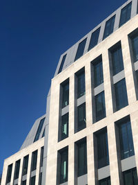 Low angle view of modern building against clear blue sky