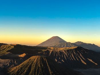 Panoramic view of arid landscape against clear sky during sunset