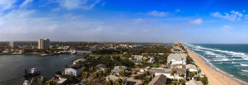 High angle view of buildings and sea against cloudy sky