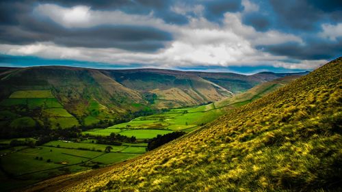 Scenic view of agricultural field against cloudy sky