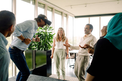 Businessman dancing while wearing virtual reality simulator during meeting at convention center