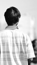 Rear view of boy standing against sky