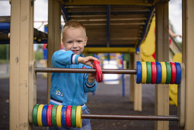 Portrait of boy standing on railing