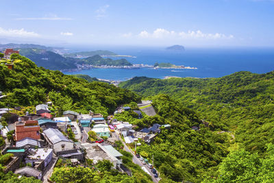 High angle view of buildings by sea against sky