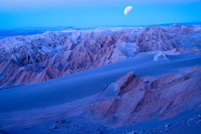 Scenic view of mountains against blue sky at night