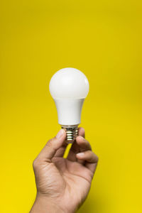 Close-up of hand holding light bulb