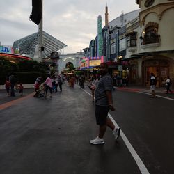 People on road against buildings in city