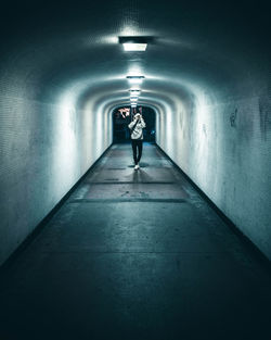 Woman in illuminated tunnel