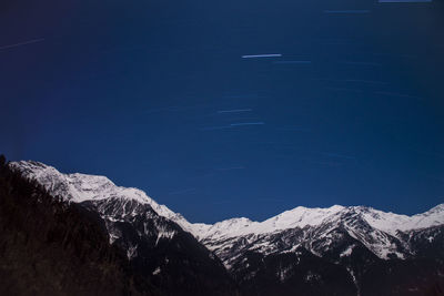 Scenic view of snowcapped mountains against blue sky