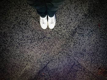 Low section of person standing on road