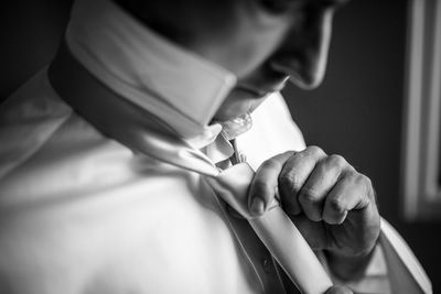 Close-up of man adjusting tie 