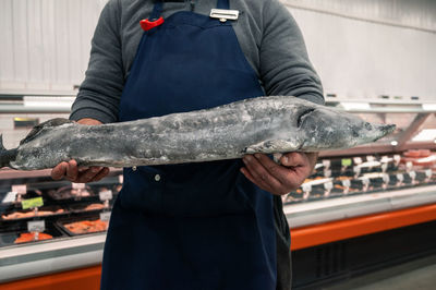 Midsection of man holding fish
