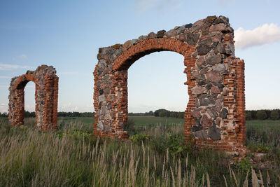 Old ruin on field against sky