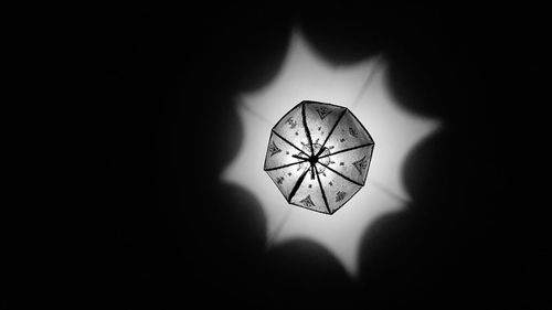 Close-up of illuminated electric lamp in darkroom