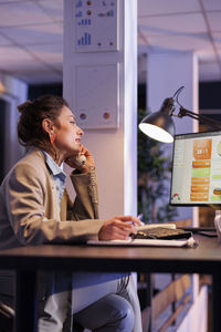 Female friends using laptop at office