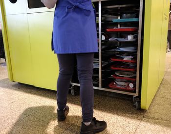 Low section of person standing by yellow cart