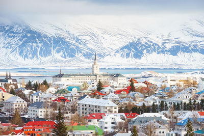 High angle view of townscape and snowcapped mountains