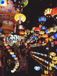 Illuminated lanterns hanging in store for sale