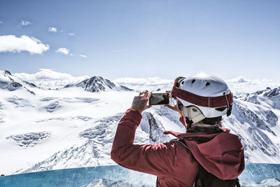 Man standing on snow covered mountain against sky