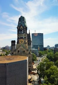 Buildings in city against cloudy sky