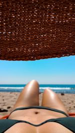 Low section of woman relaxing on beach