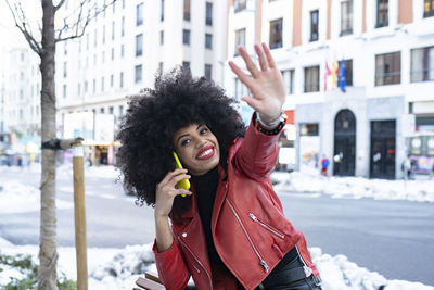Portrait of smiling young woman standing in city