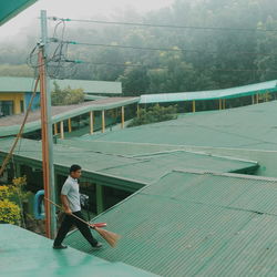 Man with umbrella against sky