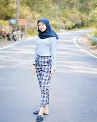 Portrait of smiling young woman on road in city