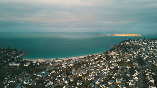 High angle view of townscape by sea against sky