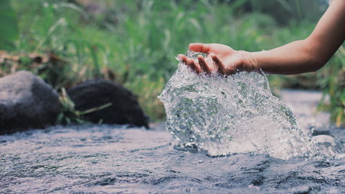 Close-up of person splashing water at river