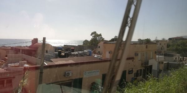 High angle view of buildings and sea against sky