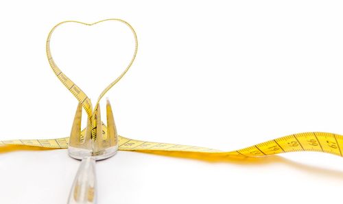 Close-up of heart shape on metal against white background