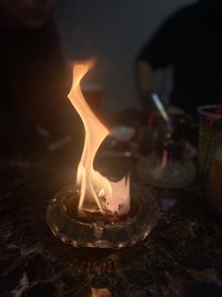 Close-up of lit candle in the dark