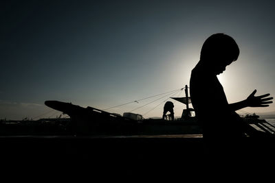 Low angle view of silhouette people against sky at sunset