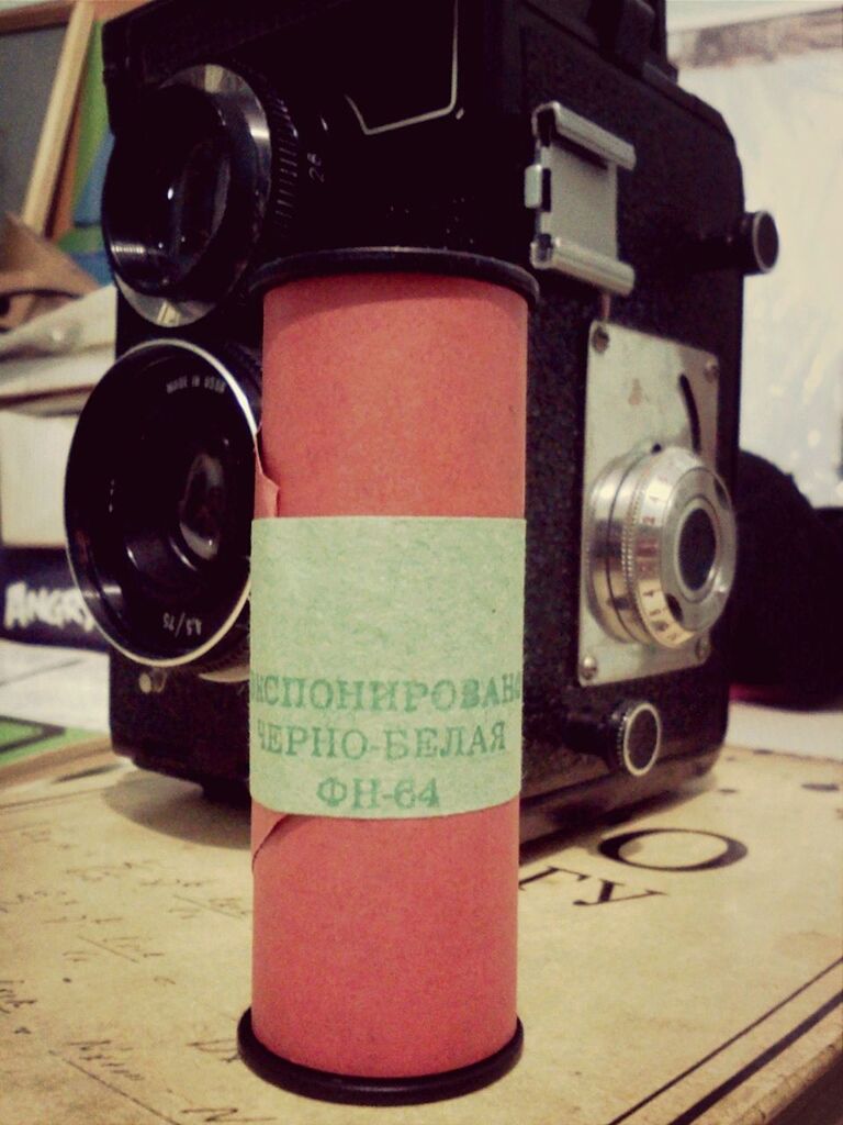 close-up, focus on foreground, communication, text, indoors, technology, still life, western script, old-fashioned, metal, car, retro styled, photography themes, red, black color, land vehicle, no people, camera - photographic equipment, table, selective focus