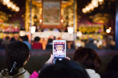 Cropped image of person photographing temple