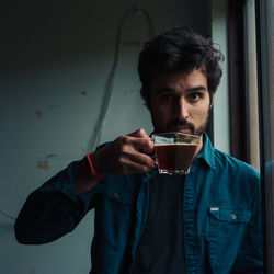 Portrait of young man drinking glass
