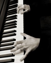 Cropped image of hands playing piano