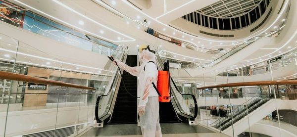 Low angle view of man working on ceiling in factory