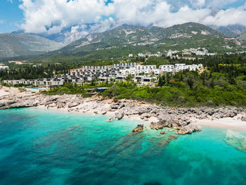 High angle view of townscape by sea against sky