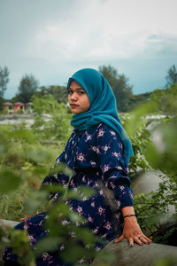 Full length of woman standing against plants