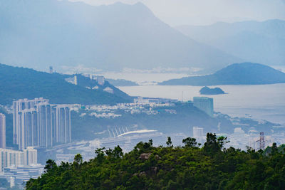 High angle view of city by sea against sky