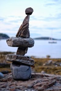 Stack of pebbles on beach against sky