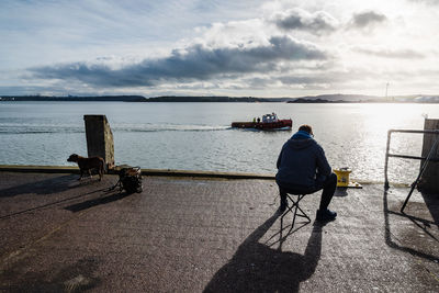 Rear view of man on sea against sky