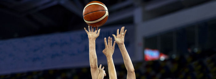 Cropped hands of men catching basketball